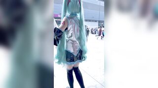 短いスカートをはいた若い女性が、脚の間にカメラとCDプレーヤーを挟み、前かがみになって、ピンクの縫い目のないパンティーを露わにしている ipcam 3