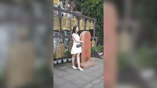 観光地で、白いワンピース姿の若い女性が写真を撮ろうとかがみ込む。カメラがその姿を至近距離までズームアップし、執拗に追尾・撮影し続けること ipcam 2